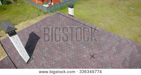 House With A Roof From A Bituminous Tile. Bituminous Tile For A Roof. A Roof From A Bituminous Tile.