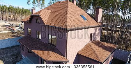 House With A Roof From A Bituminous Tile. Bituminous Tile For A Roof. A Roof From A Bituminous Tile.