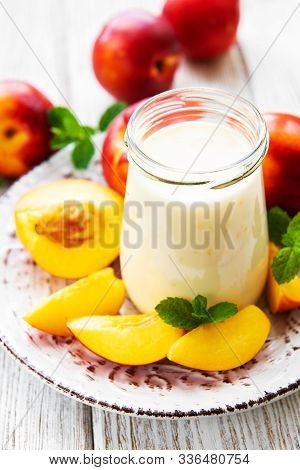 Yogurt With Fresh Nectarines On A White Wooden Table