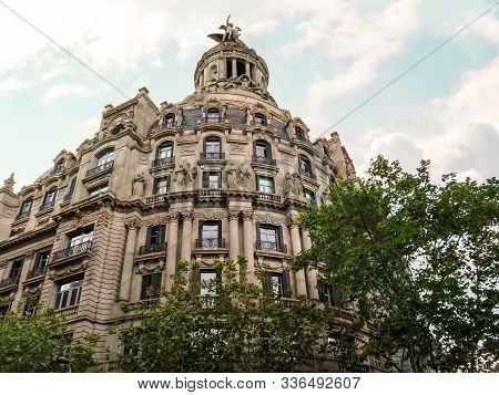 Barcelona, Spain - October 10, 2018:  A Round Building With Many Sculptures On The Facade Of The Uni