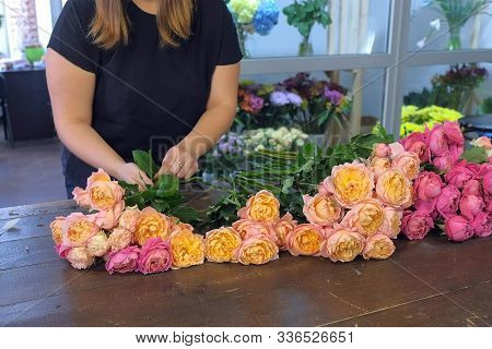 Florist Woman Making Creating Bouquet Of Pink And Orange Peonies In Flower Shop, Closeup View. Flora