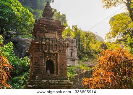 A Small Brick Pagoda At Bich Ding In Tam Coc, Vietnam With The Sun Shining Behind It During A Beauti