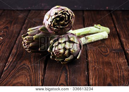 Artichokes On Rustic Background. Fresh Raw Organic Artichoke Flower.