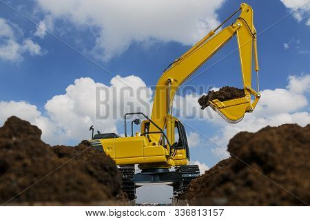 Excavators Are Digging The Soil In The Construction Site On The Blue Sky Background