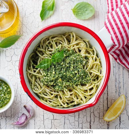 Pasta Spaghetti With Basil Pesto Sauce In Saucepan. White Wooden Background. Top View
