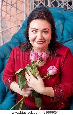 Portrait Of Fat Plump Charming Cute Woman With Black Curly Hair In Red Dress And Rose In Hands In Th
