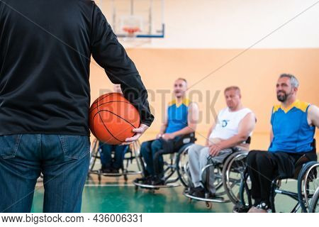 selector I explain new tactics to basketball players in wheelchairs, players sit in wheelchairs listening to the selector
