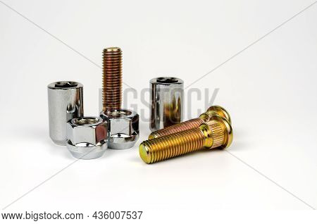 Metal Stud And Shiny Car Wheel Nuts Close-up On A White Background. Car Spare Part