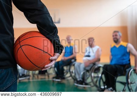 selector I explain new tactics to basketball players in wheelchairs, players sit in wheelchairs listening to the selector