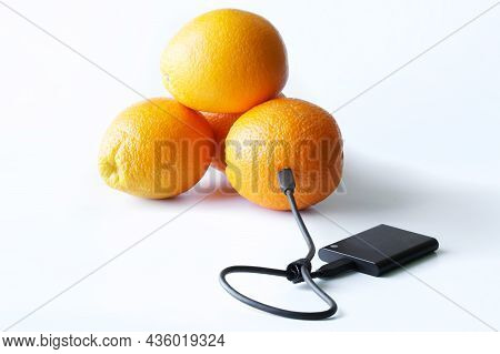 The External Ssd Is Wired To Fresh Oranges. The Concept Of Green Technologies And Data Storage In Th