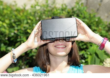 Smiling Young Girl Trying On The Virtual Reality Headset While Having Fun