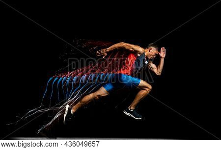 Full-length Portrait Of Young Male Athlete, Professional Runner In Motion Isolated Over Black Backgr