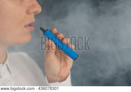 Caucasian Woman Smokes A Disposable Vape In The Studio.
