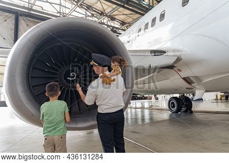 Pilot And Children Are Standing Near The Turbine And Looking At It