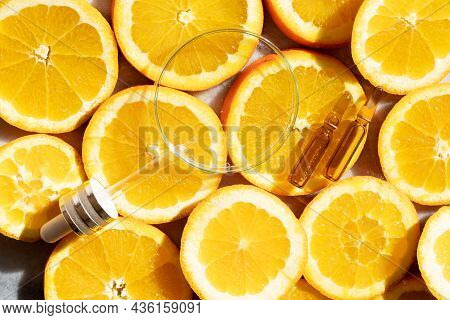 Glass Petri Dish With Transparent Pure Serum For Skin Care With Ampulas Over Natural Orange Slices, 