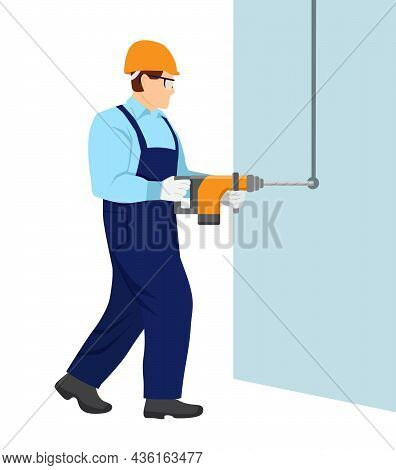 A Man In Overalls And With A Helmet On His Head Is Working With A Hammer Drill. Guy Drills A Hole In