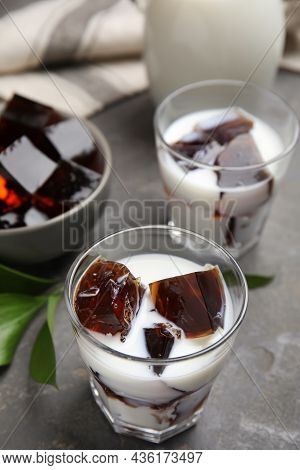 Glasses Of Milk With Delicious Grass Jelly On Grey Table, Closeup