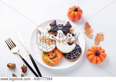 Halloween Table Setting With Gingerbread Cookies On White Plate And Cuterly On White Background. Bri
