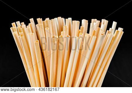 Wheat Straw For Drinking Water In Glass On Black Background. Zero Waste Concept.