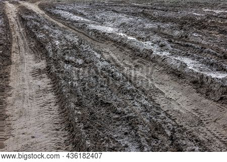 A Broken Rural Country Road. Puddles After Rain On A Dirt Road. Clay, Soil And Puddles At Cloudy Day