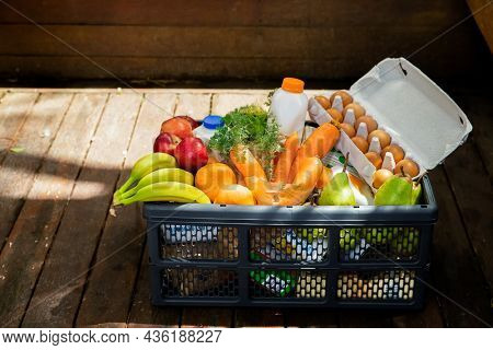 food box delivered and ordered online, milk, vegetables, eggs in a box parcel sent home, groceries delivery, online food order and delivery concept. 