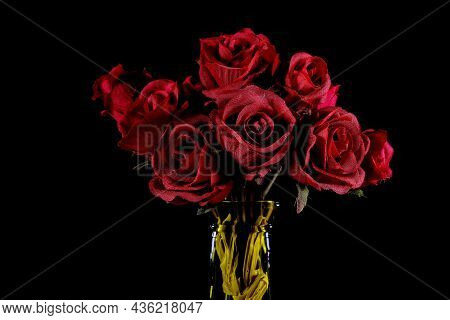 Bouquet Of Roses In A Bottle Against A Black Back Ground