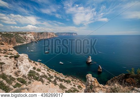 Two Rocks Stick Out Of The Water In The Middle Of The Turquoise Sea. Scenic Ocean View. Speed Boat S