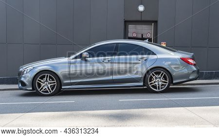 Side View Of Mercedes-benz Cls C218 Car Parked Along Dark Gray Wall Of Building Facade. Moscow, Russ