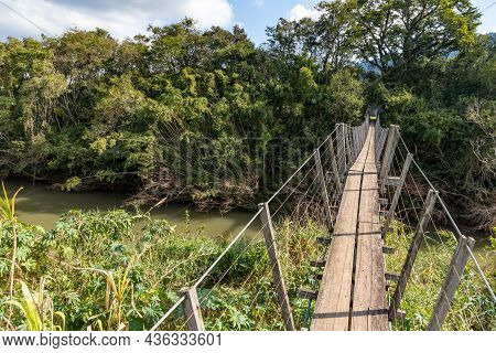 Wood And Iron Bridge Over Cadeia River With Forest Around