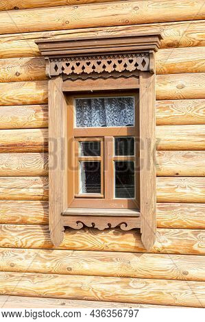Russian Traditional Wooden Architecture. Windows Of Wooden House Decorated With Wooden Carvings, Pla