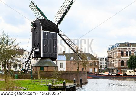 Cityscape Of Leiden, The Netherlands. View Of New Rhine River And Dutch Houses And Traditional Windm