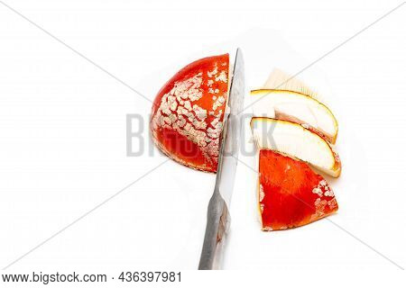 A Red Fly Agaric (amanita Muscaria) Hat Cut Into Pieces With A Table Knife On A White Background. Th