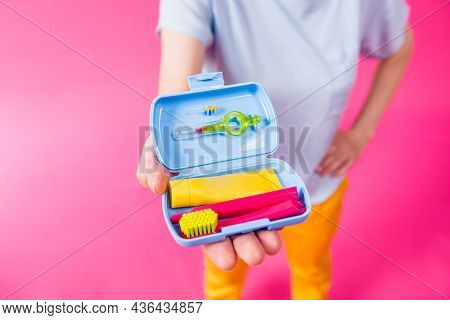 Beautiful Girl Uses A Travel Kit For Dental Care On A Pink Background