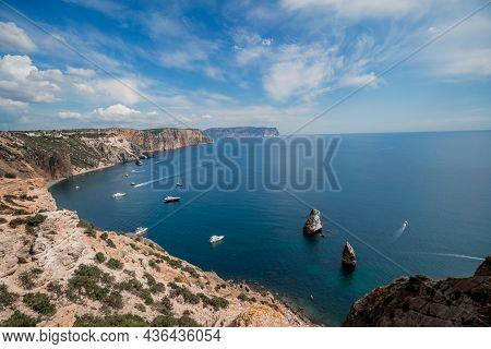 Two Rocks Stick Out Of The Water In The Middle Of The Turquoise Sea. Scenic Ocean View. Speed Boat S