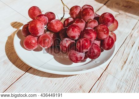 Fresh Red Grapes In A Plate On Wooden Table, Flatlay