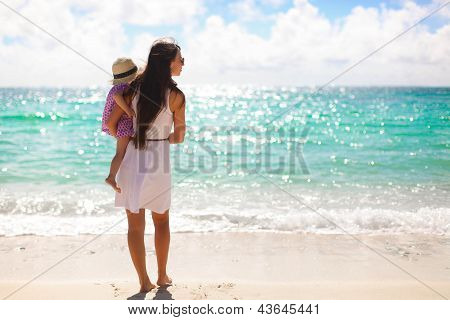 Vista posteriore di madre e figlia litlle guardando il mare