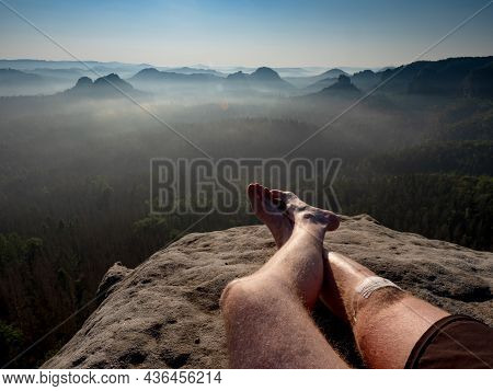 Crossed Male Barefoot Legs Of Man Relax On Mountain Summit. Hiker Lay Down And Have A Rest