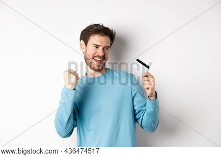 Happy Man Dancing With Plastic Credit Card, Smiling And Saying Yes, Celebrating On White Background