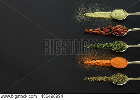 Spoons With Spices, Pepper, Chilli, Oregano For Dark Table