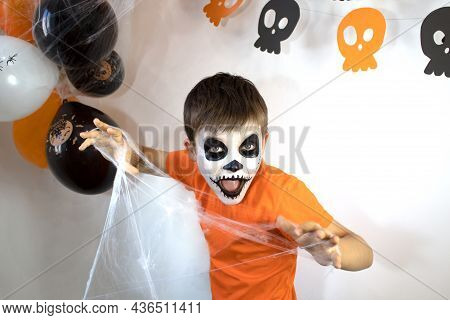 Happy Baby With Skeleton Makeup. Spider Web In The Hands Of A Boy On Halloween