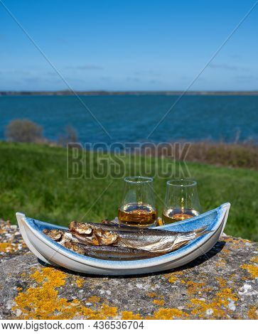Smoked Sprattus Or Sprats Sea Fish Served Outdoor With View On Blue Sea Water