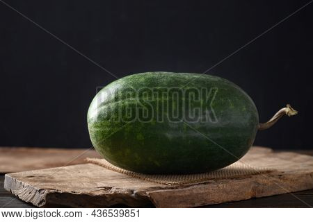 Wax Gourd, Ash Gourd Or Winter Melon On Wooden With Black Background