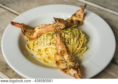 Seafood Spaghetti With Shrimps And Olive Oil In A Wooden Table