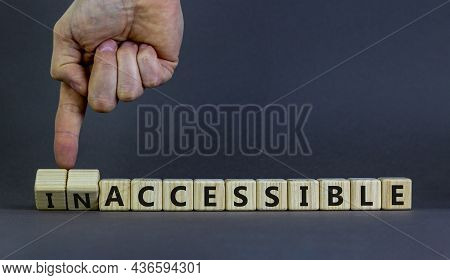 Accessible Or Inaccessible Symbol. Businessman Turns Wooden Cubes, Changes The Word Inaccessible To 