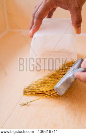 Close Up Of Male Hand Brooming Wooden Box With Small Whisk Broom And Recycled Milk Boxes As Dustpan