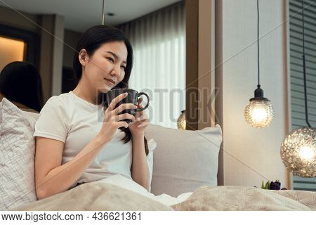 Asian Woman Holding A Cup Of Coffee In The Morning After Waking Up.