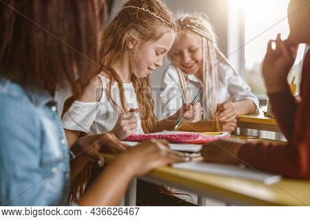 Girl Holding Pencil And Drawing In A Notebook