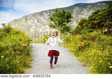 Cute Little Happy Toddler Girl Running On Nature Path In Glenveagh National Park In Ireland. Smiling