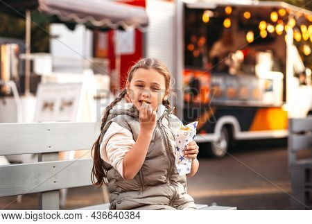 Little Girl Eating Rench Fries With Sauce At Street Cafe Outside. Concept Of Fast Food And Children.
