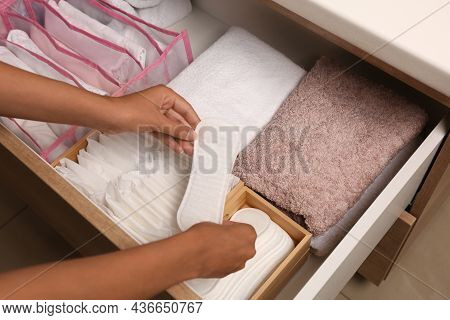 Young Woman Taking Pantyliner Out Of Drawer, Closeup